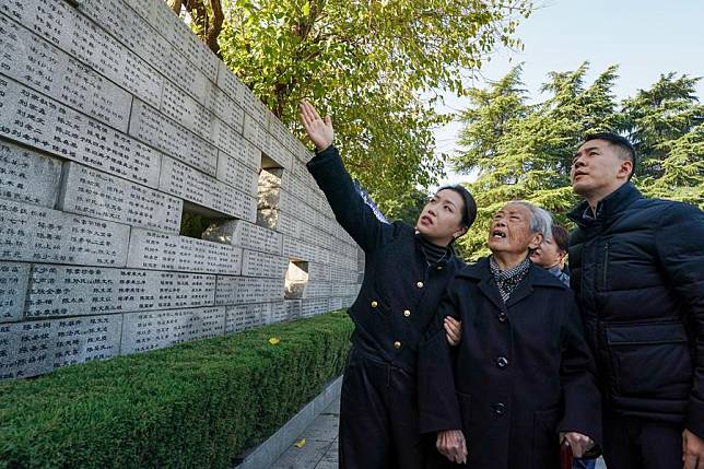 Nanjing Massacre survivors Ai Yiying (2nd R) searches for the names of her relatives, the victims of the Nanjing Massacre, in front of the &ldquo;wailing wall&rdquo; outside the Memorial Hall of the Victims in Nanjing Massacre by Japanese Invaders, in Nanjing, east China's Jiangsu Province, Dec. 1, 2024. The 2024 family commemoration for victims of the Nanjing Massacre was launched on Sunday in Nanjing, capital of east China's Jiangsu Province. It came less than a fortnight before China's national memorial day on Dec. 13, which was inaugurated ten years ago. (Xinhua/Li Bo)