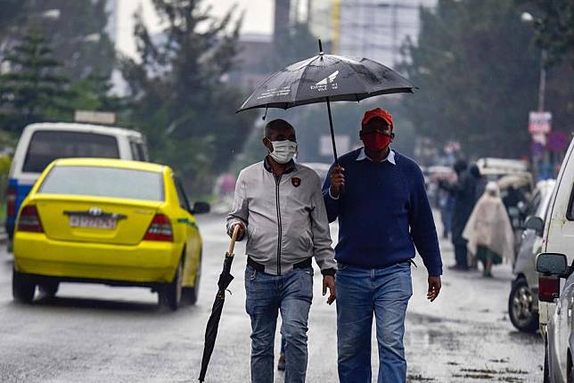 People wearing face masks walk along a street in Addis Ababa, Ethiopia, Sept. 1, 2020. (Photo by Michael Tewelde/Xinhua)