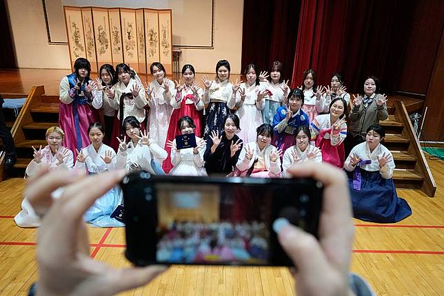 南韓首爾中學女生穿著傳統韓服參與正式儀式。（美聯社）