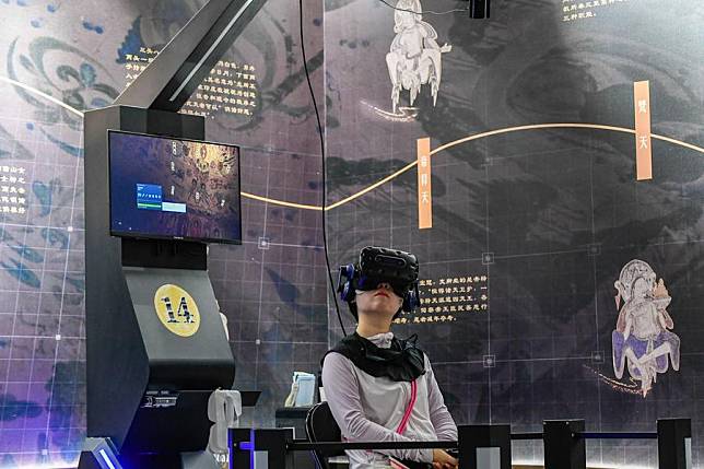 A visitor uses virtual reality (VR) equipment to visit the Mogao Grottoes in Dunhuang, northwest China's Gansu Province, July 22, 2024. (Xinhua/Lang Bingbing)