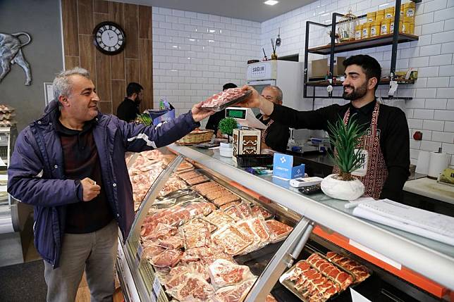 A man buys meat at a butcher shop in Ankara,Türkiye, on March 25, 2024. (Photo by Mustafa Kaya/Xinhua)