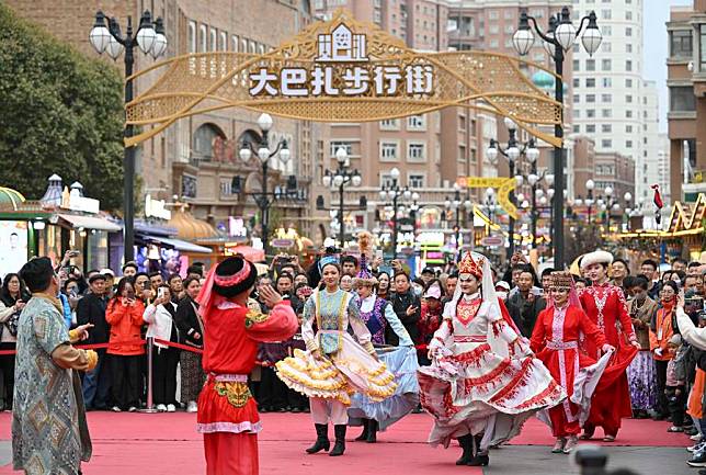 Attendees of the 6th World Media Summit watch performance at the grand bazaar in Urumqi, northwest China's Xinjiang Uygur Autonomous Region, Oct. 16, 2024. (Xinhua/Hu Huhu)