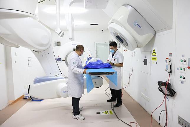 Staff members adjust devices at a treatment room for heavy ion radiotherapy in Gansu Wuwei Tumor Hospital in Wuwei, northwest China's Gansu Province, Oct. 15, 2024. (Xinhua/Lyu Shuai)