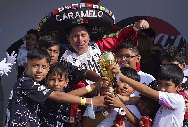 墨西哥球迷與世足賽冠軍盃複製品合影。（美聯社資料照）