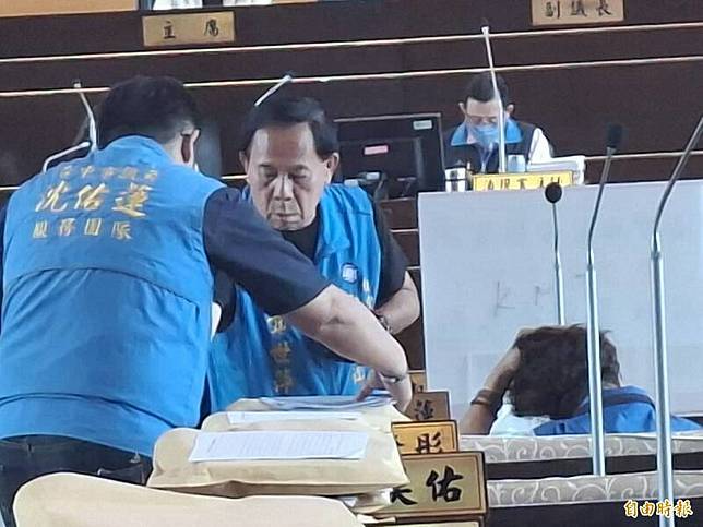 台中市議員沈佑蓮(右，背對鏡頭坐者)質詢完後在座位上狂吐，助理急忙遞衛生紙。(記者蘇金鳳攝)