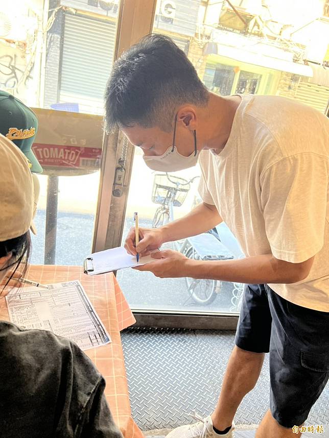 楊皓崴認真記錄客人的點餐需求。(記者李紹綾攝)