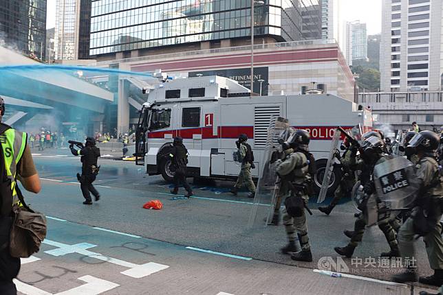 香港民眾15日再次上街遊行反送中，遊行結束後，部分示威者轉而包圍政府總部，警方在傍晚6時前後動用裝有藍色染劑的水炮車強力驅散他們。   圖：中央社提供。