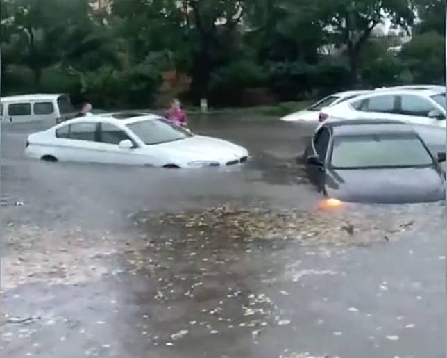 山東省青島昨下午爆發大雨，積水一度高達半人高，車輛都被水沖走。   圖:翻攝自微博