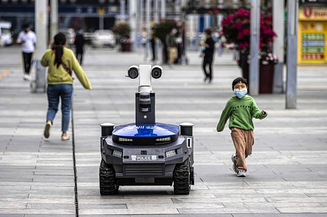 A police security robot patrols near the high-speed railway station in Shenzhen on March 6. It can warn people if they are not wearing masks, and check their body temperature and identity. Photo: EPA-EFE