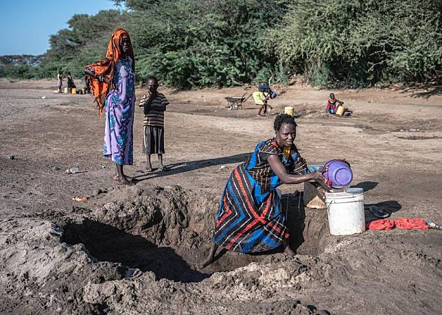 Residents collect seepage groundwater at a dry riverbed in Kakuma in Kenya's northwestern county of Turkana on June 19, 2024. (Xinhua/Wang Guansen)