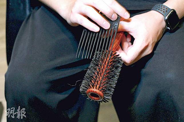 挑走頭髮——若梳齒之間有頭髮纏繞，可用另一把梳挑走。（呂瑋宗攝）