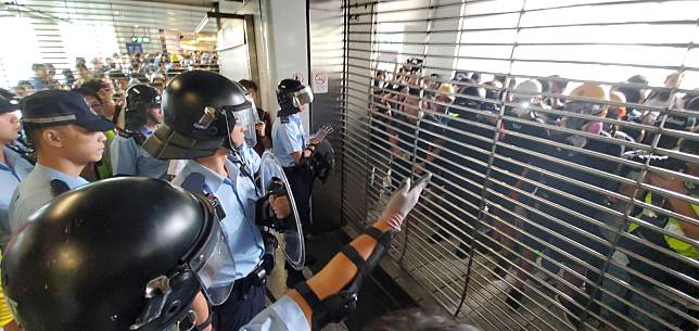 防暴警員到閘外協助後，港鐵職員成功將A出口鐵閘關閉。