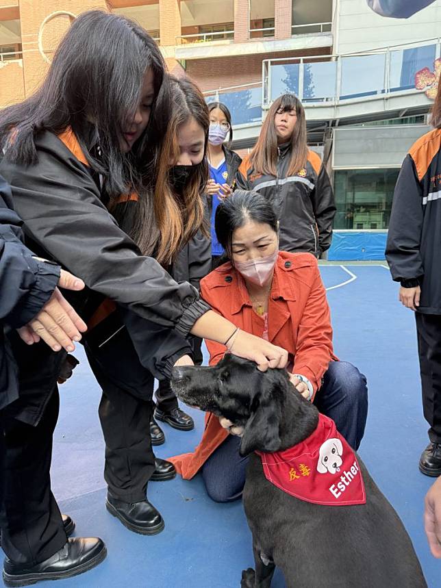 台南憲兵隊攜退役緝毒犬到亞餐反毒宣教，學生搶著親近緝毒犬。（亞洲餐旅學校提供）