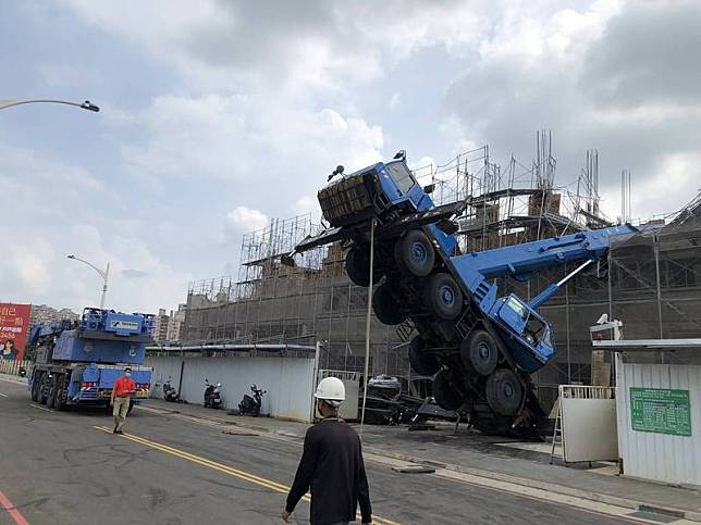桃園區一處施工工地發生100噸大吊車重心不穩傾倒在建物上。(警方提供)
