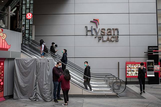 People wearing protective masks ride on escalators at the Hysan Place shopping mall in Causeway Bay shopping district in Hong Kong. Photo: Bloomberg
