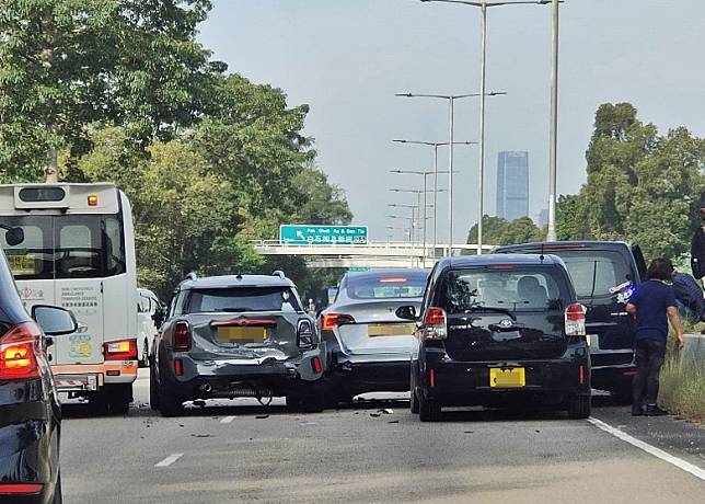 客貨車被夾在石壆及私家車之間。