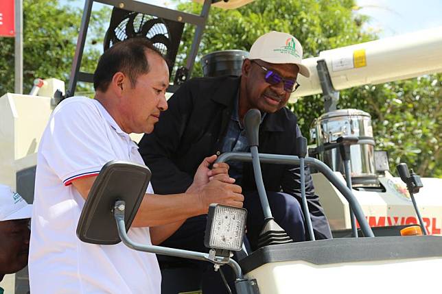 Guo Changyou, chief of the 11th Chinese Agricultural Technical Assistance Mission (MATAC) in Cote d'Ivoire, helps Yacouba Dembele &reg;, general director of the Agency for the Development of the Rice Sector in Cote d'Ivoire, operate an agricultural machine in Guiguidou area, Divo Province in southern Cote d'Ivoire, May 31, 2024. (Xinhua/Zhang Jian)