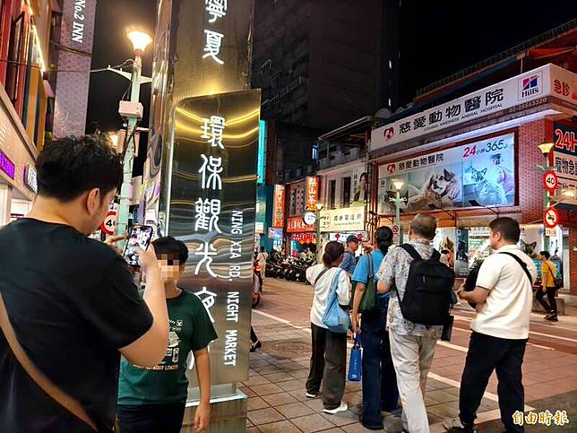 「寧夏環保觀光夜市」招牌閃耀著「環保」與「觀光」光芒，但光鮮亮麗背後，幾公尺外的草叢裡，老鼠正如雨後春筍般竄出。(記者王藝菘攝)