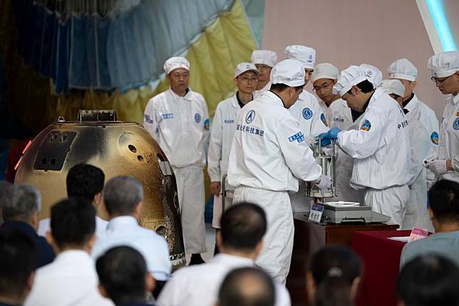 Researchers weigh the Chang'e-6 lunar samples during a returner opening ceremony at the China Academy of Space Technology under the China Aerospace Science and Technology Corporation in Beijing, capital of China, June 26, 2024. (Xinhua/Jin Liwang)