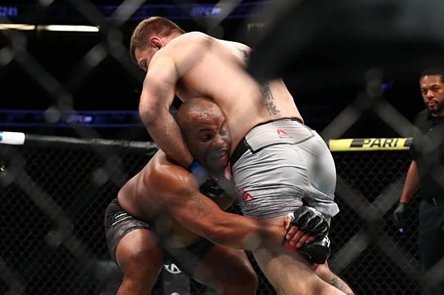 Daniel Cormier takes Stipe Miocic to the floor in the first round. Photos: AFP