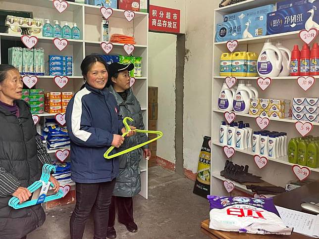 This photo taken with a mobile phone shows villagers purchasing daily supplies using the points they gained in exchange for good deeds at a “point store” in Zuolan Township of southwest China's Chongqing Municipality, Feb. 22, 2023. (Xinhua/Zhou Siyu)