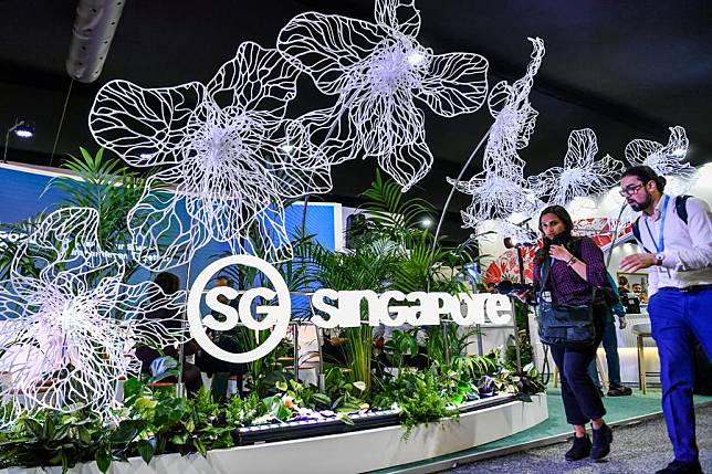 Attendees are seen at an exhibition area of the 29th session of the Conference of the Parties to the United Nations Framework Convention on Climate Change (UNFCCC) in Baku, Azerbaijan, Nov. 11, 2024. (Xinhua/Cao Yang)