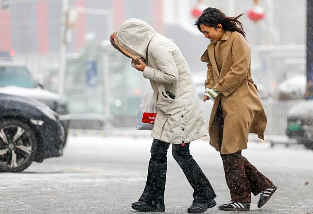 People walk in snow in Urumqi, northwest China's Xinjiang Uygur Autonomous Region, Nov. 14, 2024. (Xinhua/Wang Fei)