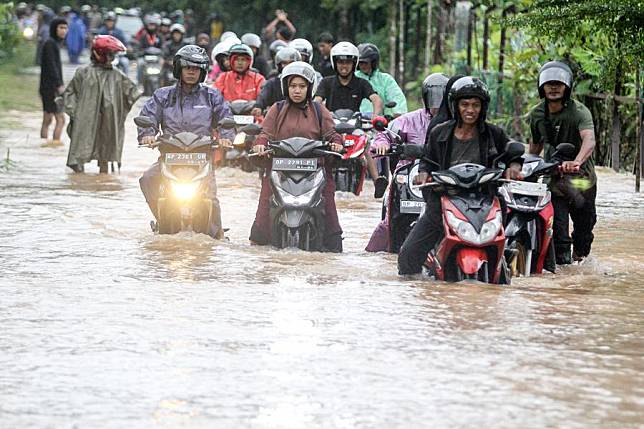 Motorists wade through flood water after heavy rain hit Tanjungpinang, the capital of Riau Islands province, Indonesia, Jan. 11, 2025. (Photo by Yuli Seperi/Xinhua)