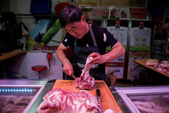 A butcher cuts pork meat at a market in Beijing. China’s per capita pork consumption of 30kg last year was on par with South Korea. Photo: AFP