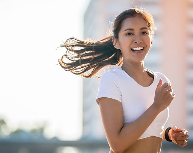 Asian Young fitness sport woman running and smiling on city roa