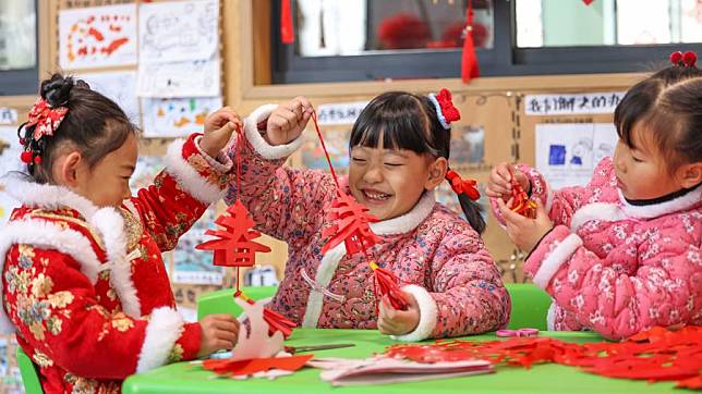 Children make paper cutting works at a kindergarten in Yuping Dong Autonomous County of Tongren City, southwest China's Guizhou Province, Jan. 16, 2024. (Photo by Hu Panxue/Xinhua)