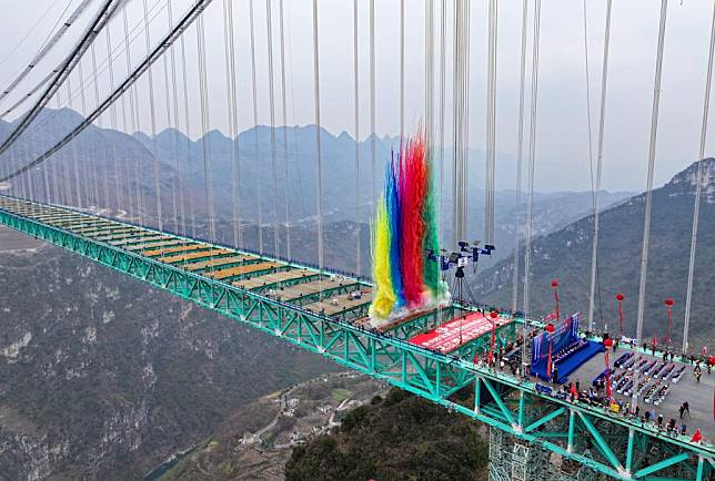 An aerial drone photo taken on Jan. 17, 2025 shows a ceremony marking the completion of the main structure of the Huajiang Grand Canyon Bridge in southwest China's Guizhou Province. China on Friday finished the construction of the main structure of the Huajiang Grand Canyon Bridge in its southwestern Guizhou Province, which is set to become the world's tallest bridge.A project of Guizhou Transportation Investment Group Co., Ltd., the suspension bridge has a vertical height of 625 meters from the bridge deck down to the river surface.The 2,890-meter bridge, with a span of 1,420 meters, is also the world's largest span bridge to be built in a mountainous area. (Xinhua/Liu Xu)