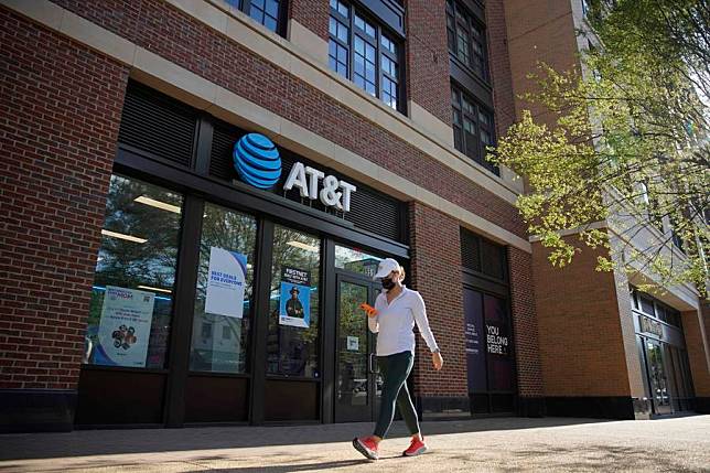 A woman walks by an AT&amp;T store in Washington, D.C., the United States, May 5, 2021. (Photo by Ting Shen/Xinhua)