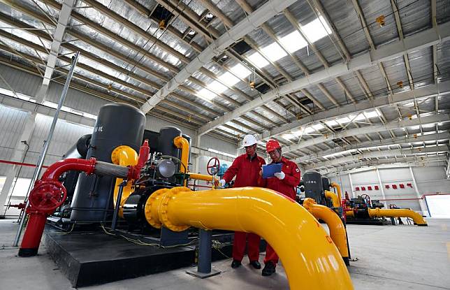This photo taken on June 25, 2022 shows workers checking equipment at the workshop of a coalbed methane mining base in Qinshui County, north China's Shanxi Province. (Xinhua/Wang Feihang)