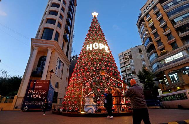 People pose for photos in front of Christmas decorations in Beirut, Lebanon, Dec. 14, 2024. (Xinhua/Bilal Jawich)