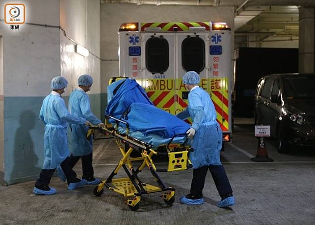 確診新冠肺炎的警員，其家人由醫護人員用擔架床抬上救護車。(余宏基攝)