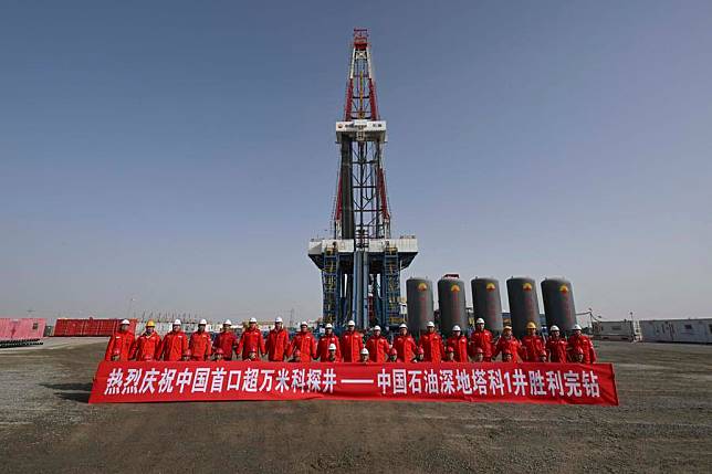 Staff members pose for a group photo as they celebrate the completion of the drilling of &ldquo;Shenditake 1,&rdquo; an ultra-deep borehole reaching 10,910 meters, in the hinterland of the Taklimakan Desert in the Tarim Basin, northwest China's Xinjiang Uygur Autonomous Region, Feb. 20, 2025. China National Petroleum Corporation announced Thursday that it has completed the drilling of the deepest vertical well in Asia, as a borehole reached a depth of 10,910 meters in China's northwestern desert. (Xinhua/Hu Huhu)