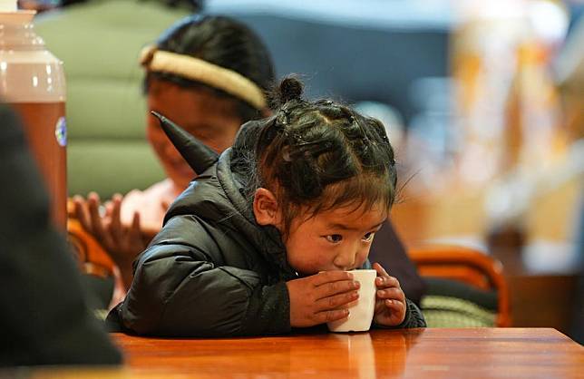 A child enjoys buttered tea at a Tibetan-style teahouse in Seni District of Nagqu, southwest China's Xizang Autonomous Region, Feb. 13, 2025. (Xinhua/Jigme Dorje)