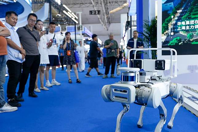 Visitors look at an inspection robotic dog at the booth of China Huadian Group at the 8th China-Eurasia Expo in Urumqi, northwest China's Xinjiang Uygur Autonomous Region, June 27, 2024. (Xinhua/Chen Shuo)