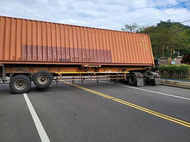 貨櫃車司機想要迴轉，未料路幅不夠寬，直接卡在路中央。(記者吳昇儒翻攝)
