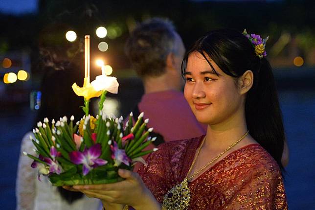 A woman prepares to release a water lantern during the Loy Krathong Festival by the Chao Phraya River in Ayutthaya, Thailand, Nov. 15, 2024. (Xinhua/Rachen Sageamsak)