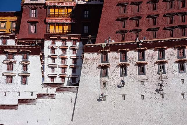 Workers paint the wall of the Potala Palace during an annual renovation of the ancient architectural complex in Lhasa, southwest China's Xizang Autonomous Region, Oct. 30, 2024. (Xinhua/Tenzing Nima Qadhup)