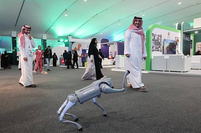 People watch the performance of a robot dog launched by the Chinese company, Unitree Robotics, at the Future of Media Exhibition in Riyadh, Saudi Arabia, on Feb. 20, 2025. (Xinhua/Yin Ke)