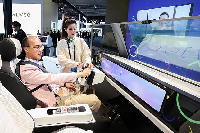 A visitor sits in a simulated driving cabin at the booth of Volkswagen at the Automobile Exhibition Area during the seventh China International Import Expo (CIIE) in east China's Shanghai, Nov. 7, 2024. (Photo by Chang Nengjia/Xinhua)