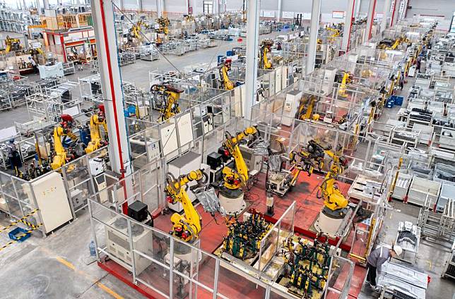 An aerial drone photo taken on Jan. 8, 2024 shows robotic arms processing components for new energy vehicles at a private company in Changxing Economic and Technological Development Zone of Huzhou City, east China's Zhejiang Province. (Photo by Tan Yunfeng/Xinhua)