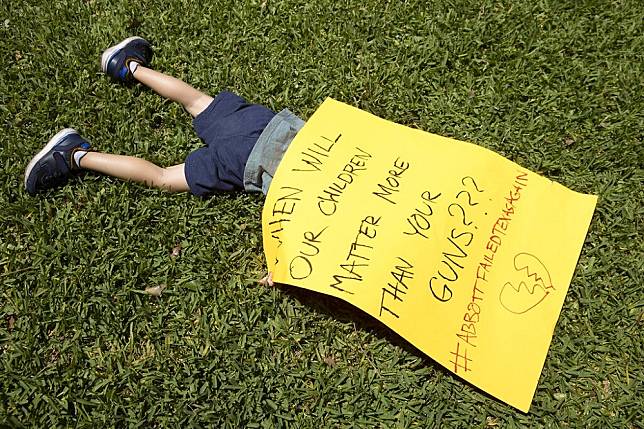 一名3歲的男童25日參加抗議活動，海報上寫著：我們小朋友什麼時候才能比你們的槍更重要？（美聯社）