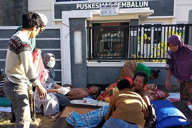 印尼龍目島29日震災受傷者於一間醫院外接受照護。（湯森路透）