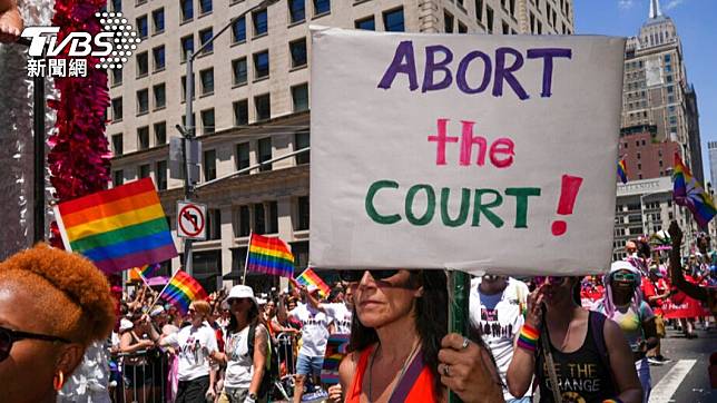 紐約市2022年同志驕傲大遊行26日登場，民眾高舉標語抗議最高法院日前推翻女性墮胎權的決議。（圖／達志影像美聯社）