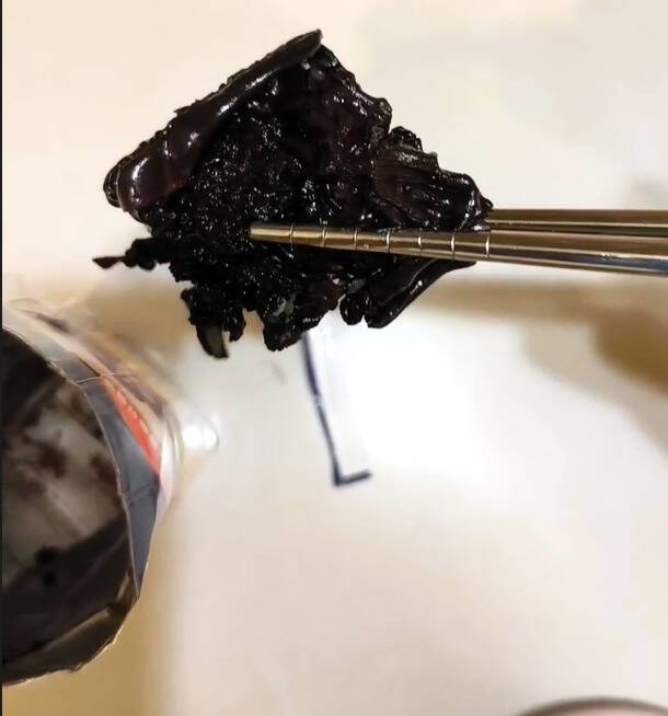 民眾摸到鋁箔包裝有硬物，剪開包裝發現一大團黑色異物。(陳先生提供)