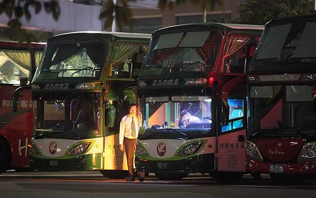 阿羅哈客運5日晚間驚爆財務危機，阿羅哈駁斥媒體爆料。圖為兩位行駛台北-高雄的阿囉哈客運司機5日夜間在停車場打電話瞭解狀況。（張鎧乙攝）
